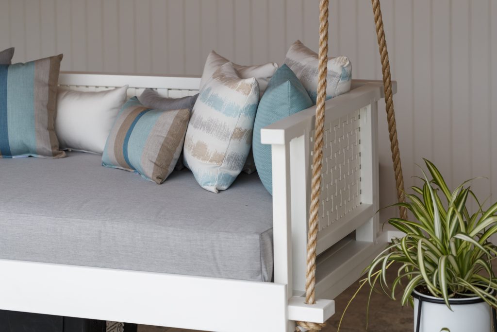 Swinging couch suspended by thick ropes