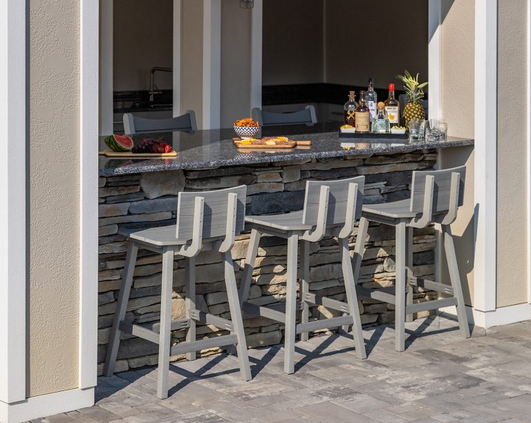 Outdoor stone bar with three low-backed barstools